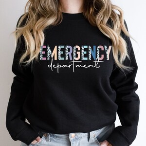 May include: Black sweatshirt with the text "EMERGENCY department" in colorful letters with a leopard print pattern.