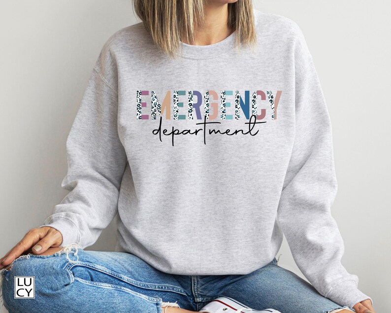 May include: A gray sweatshirt with the text "EMERGENCY department" in colorful letters with a white and black leopard print pattern.