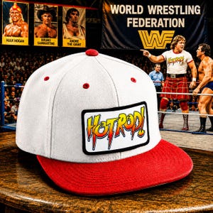May include: A white baseball cap with a red brim and a red button on top. The front features a rectangular patch with a black border and the text "HOTROD!" in stylized yellow and orange letters with a red outline, set against a white background.