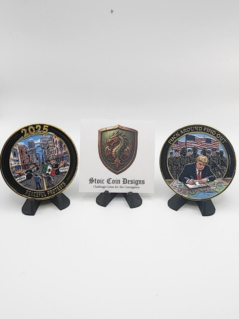 Puede incluir: Tres monedas de colecci&oacute;n en exhibici&oacute;n. Una moneda presenta una escena de la ciudad con el texto "2025 PEACEFUL PROTESTS". Otra moneda tiene el texto "FUCK AROUND FIND OUT". Una tarjeta en el centro dice "Stoic Coin Designs Challenge Coins for the Courageous."