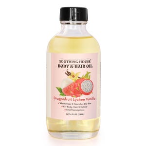 May include: A clear glass bottle of body and hair oil with a black cap. The label features the text "SOOTHING HOUSE BODY & HAIR OIL" and "Dragonfruit Lychee Vanilla." The label also includes a graphic of a dragon fruit and vanilla bean. The bottle contains 4 fl oz (118ml) of oil.
