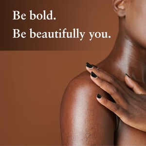 May include: A person's shoulder and arm with black nail polish, touching their shoulder. The background is a solid brown color. Text in white says, "Be bold. Be beautifully you."