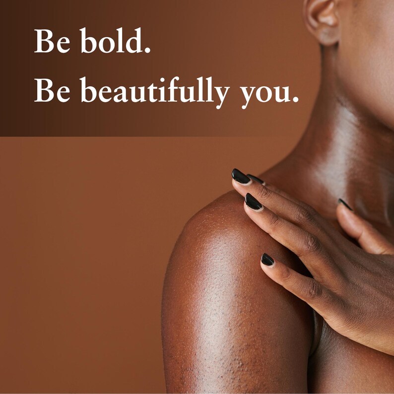 May include: A person's shoulder and arm with black nail polish, touching their shoulder. The background is a solid brown color. Text in white says, "Be bold. Be beautifully you."