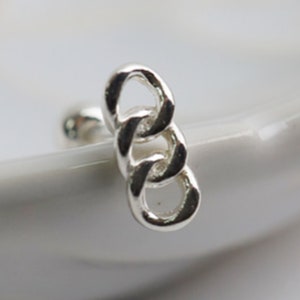 May include: Silver chain link nose ring. The ring is made of three connected links.