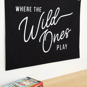 May include: Black canvas banner with white text that reads "Where the Wild Ones Play".