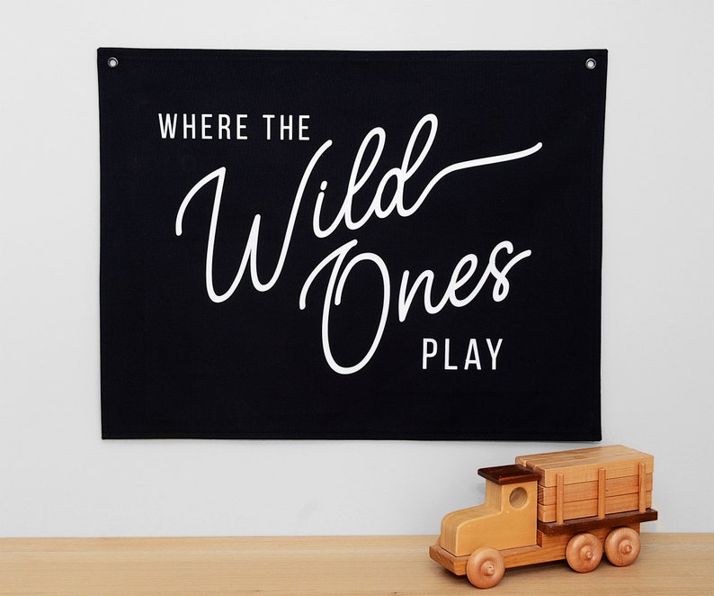 May include: Black canvas wall banner with white text that reads "Where the Wild Ones Play".