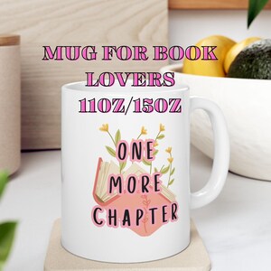 Könnte beinhalten: Weißer Keramikbecher mit dem Text "MUG FOR BOOK LOVERS" und "ONE MORE CHAPTER" in Rosa. Die Tasse zeigt auch eine Buchgrafik mit floralen Akzenten. Erhältlich in 312 ml und 425 ml.