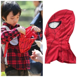 Op de afbeelding: Rood en zwart Spiderman-masker met een gaasoogopening. Het masker is gemaakt van zacht materiaal en heeft een capuchon.