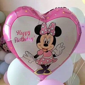 May include: A pink heart-shaped balloon with a Minnie Mouse character and the text "Happy Birthday!" printed on it. The balloon is surrounded by other balloons in various colors.