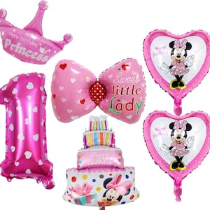 May include: A collection of pink foil balloons for a birthday celebration. Includes a crown, a number one, a bow, two heart-shaped balloons with Minnie Mouse, and a cake-shaped balloon. The balloons have text that says "Happy Birthday Princess" and "Sweet little Lady".