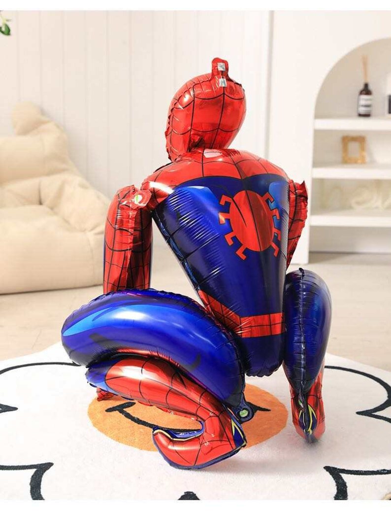 May include: A large, red and blue Spider-Man shaped balloon. The balloon is inflated and features the character's iconic design, including a red mask and suit with blue accents. The balloon is designed to stand upright.