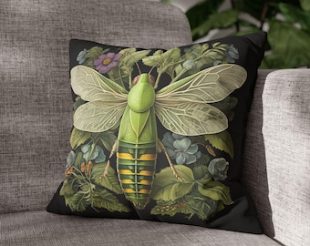 May include: A black throw pillow with a green and yellow insect illustration. The insect has large wings and is surrounded by green leaves and purple flowers.