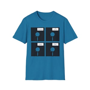 May include: A teal t-shirt featuring a graphic of four floppy disks. Each disk has a label: "Pictures," "My Memories," "Games," and "Files." The design is in black and white, creating a retro, tech-inspired look.