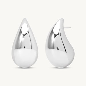 Puede incluir: Un par de pendientes de plata pulida con forma de lágrima. Los pendientes tienen una superficie lisa y reflectante, y un poste para orejas perforadas. El diseño es minimalista y moderno, adecuado para el uso diario o ocasiones especiales.