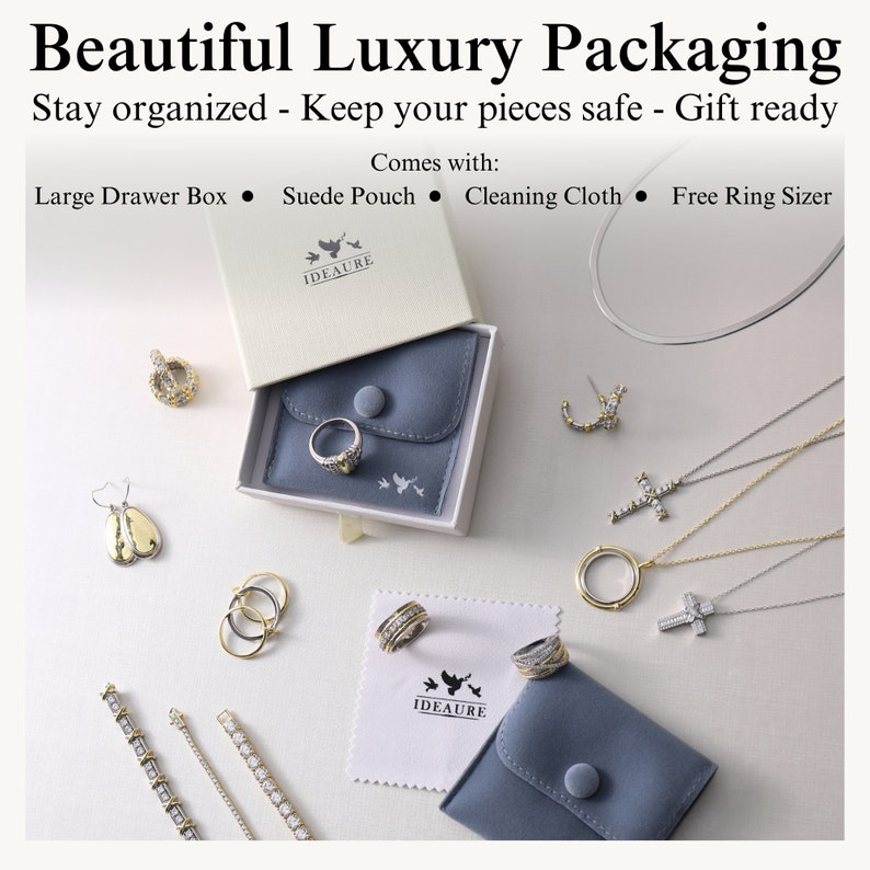 May include: A white box with a blue velvet pouch inside. The box has the text "IDEAURE" on it. The pouch has a button closure and is surrounded by various jewelry pieces, including earrings, necklaces, rings, and bracelets. The text "Comes with: Large Drawer Box, Suede Pouch, Cleaning Cloth, Free Ring Sizer" is at the top of the image.
