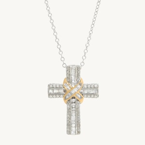 Puede incluir: Un collar de cadena de plata con un colgante de cruz engastado con diamantes. La cruz est&aacute; hecha de dos capas de diamantes, con una banda dorada en el centro.