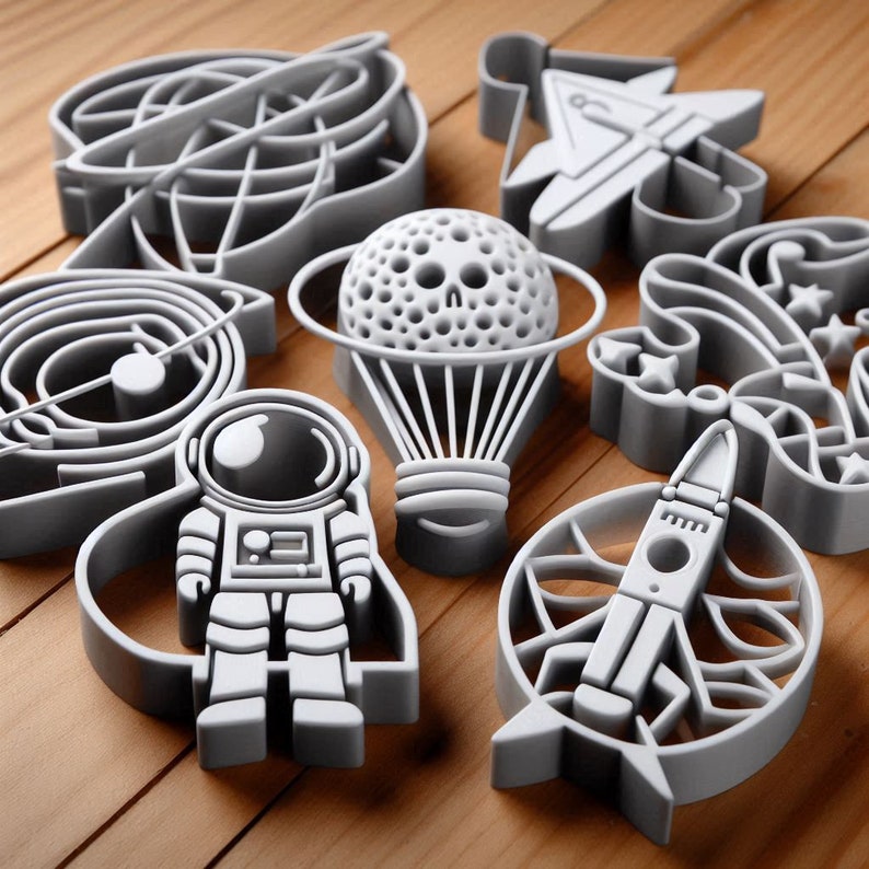 May include: A set of eight gray plastic cookie cutters shaped like an astronaut, a hot air balloon, a rocket ship, a spaceship, a galaxy, a star, a swirl, and a flower.