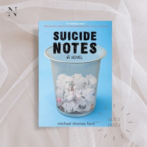 Könnte beinhalten: Ein blauer Buchumschlag mit einem weißen Mülleimer, der mit zerknülltem Papier gefüllt ist. Der Titel des Buches lautet "Suicide Notes" von Michael Thomas Ford. Der Text "A Novel" ist unter dem Titel gedruckt. Der Text "BUY 5 FREE 1" ist in der unteren rechten Ecke des Umschlags gedruckt.