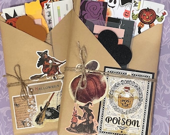 May include: Two brown paper envelopes decorated with Halloween themed stickers. The envelopes are tied with twine and feature images of pumpkins, witches, ghosts, and a skull and crossbones. The text "Halloween" and "Poison" are visible on the envelopes.