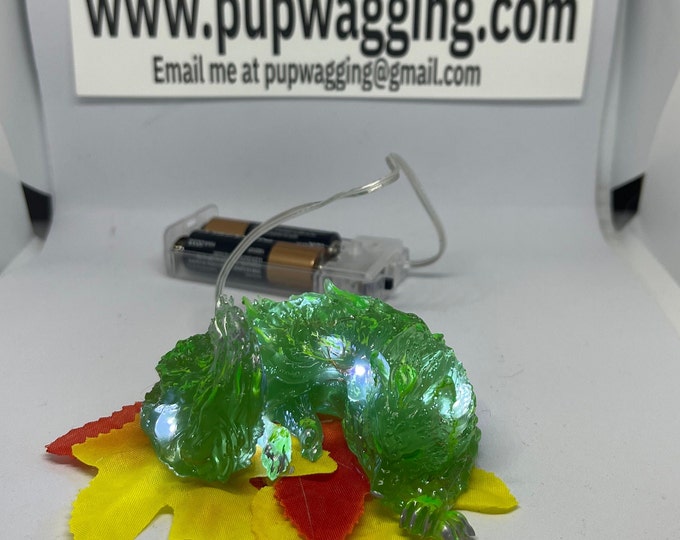 Green wolf Spirit glow in the dark highlights on a bed of leaves with LED lights free black light keychain included
