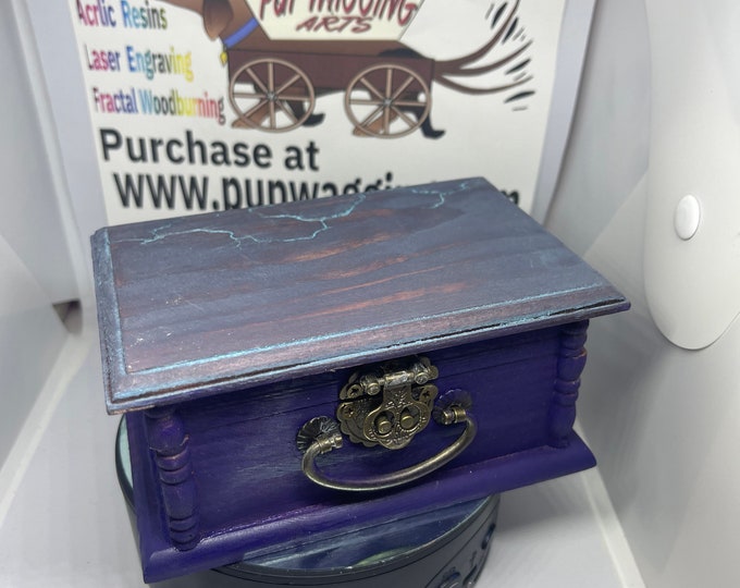 Purple and blue keepsake box with fractal wood-burning lighting on it