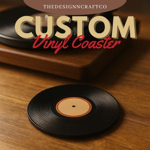 Puede incluir: Posavasos de vinilo negro con una etiqueta central marrón, sobre una superficie de madera. El posavasos tiene una textura acanalada y un pequeño punto negro en el centro. El texto "CUSTOM Vinyl Coaster" se muestra arriba.