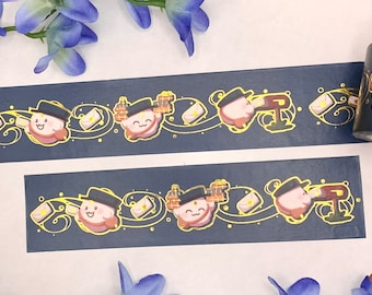Op de afbeelding: Een rol washi tape met een herhalend patroon van een roze figuur met een hoed die een brief, een brievenbus en een bakstenen gebouw draagt. De tape is op een wit oppervlak met blauwe bloemen.