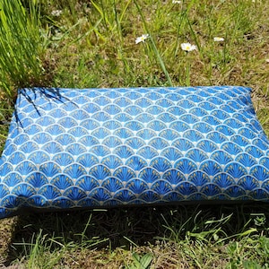 Könnte beinhalten: Ein blaues und goldenes Kissen mit einem Muster und einem Seilgriff. Das Kissen ist aus einem weichen, strapazierfähigen Stoff gefertigt und perfekt, um jedem Raum einen Hauch von Stil zu verleihen.