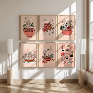 May include: Six framed art prints with food illustrations. Each print features a different dish, including ramen, pizza, and sushi, in a minimalist style with black line art on a pink background. The frames are gold.