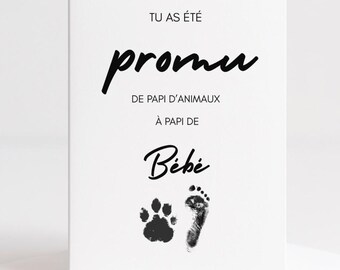 May include: A white greeting card with black text and paw print and footprint graphics. The text reads "Tu as été promu de papi d'animaux à papi de Bébé."