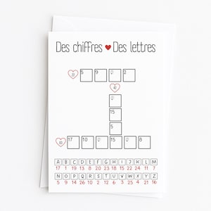 May include: A white card featuring a crossword puzzle with the text "Des chiffres Des lettres". The puzzle has numbered clues and a letter key. Red heart icons are placed next to some numbers, adding a decorative touch.
