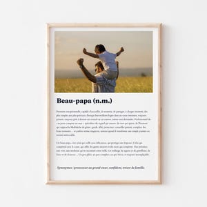 Può includere: Una stampa incorniciata con una foto di un uomo che porta un bambino sulle spalle in un campo. La stampa include il testo "Beau-papa (n.m.)" e una definizione in francese. La cornice è in legno chiaro.