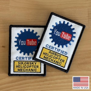 May include: Two white patches with black borders. Each patch features a blue gear with the YouTube logo and the words "CERTIFIED" and "AIRBUS HELICOPTER MECHANIC" or "SIKORSKY HELICOPTER MECHANIC" in yellow. The American flag is in the corner.