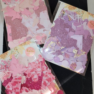 Może przedstawiać: Trzy torebki konfetti, każda z innymi kolorami i kształtami. Torebki są oznaczone napisem "Dziękujemy za zam&oacute;wienie". Konfetti jest r&oacute;żowe, fioletowe i białe.