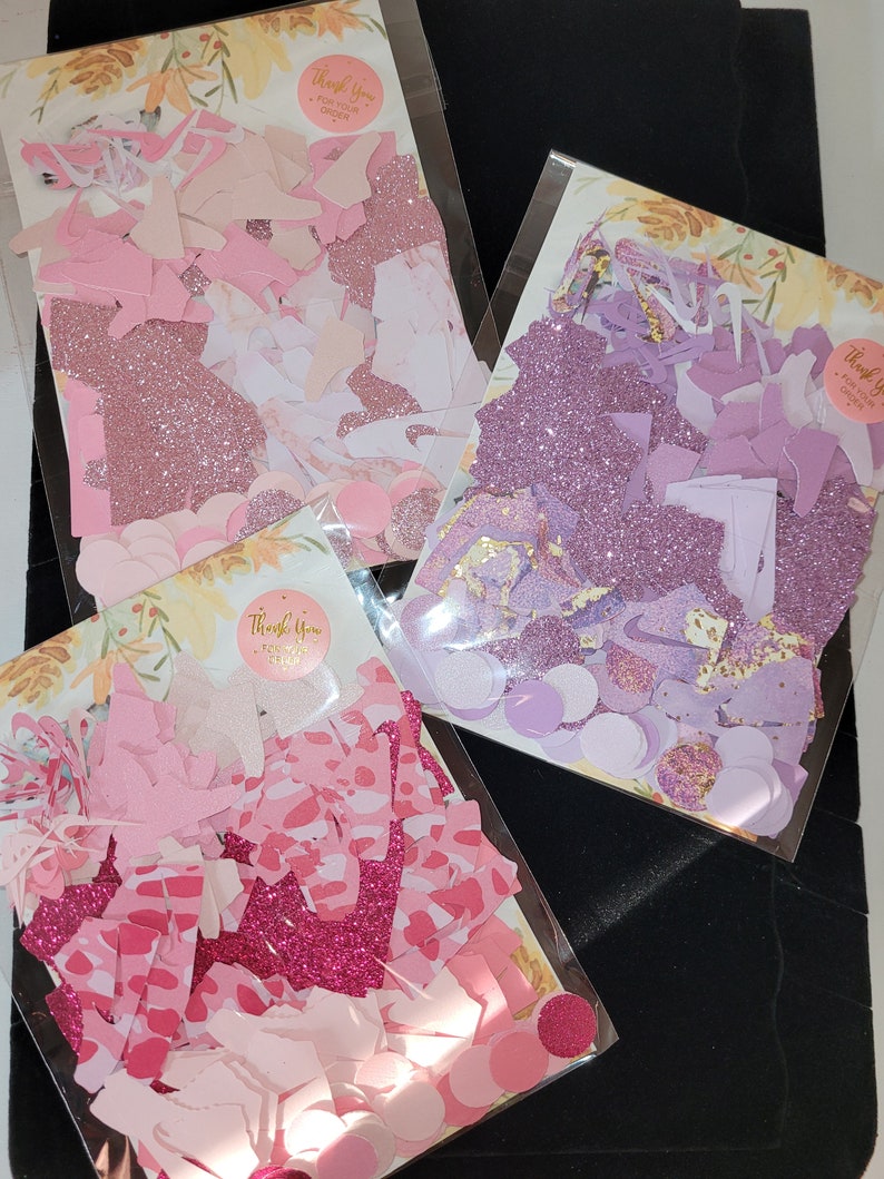 Może przedstawiać: Trzy torebki konfetti, każda z innymi kolorami i kształtami. Torebki są oznaczone napisem "Dziękujemy za zam&oacute;wienie". Konfetti jest r&oacute;żowe, fioletowe i białe.