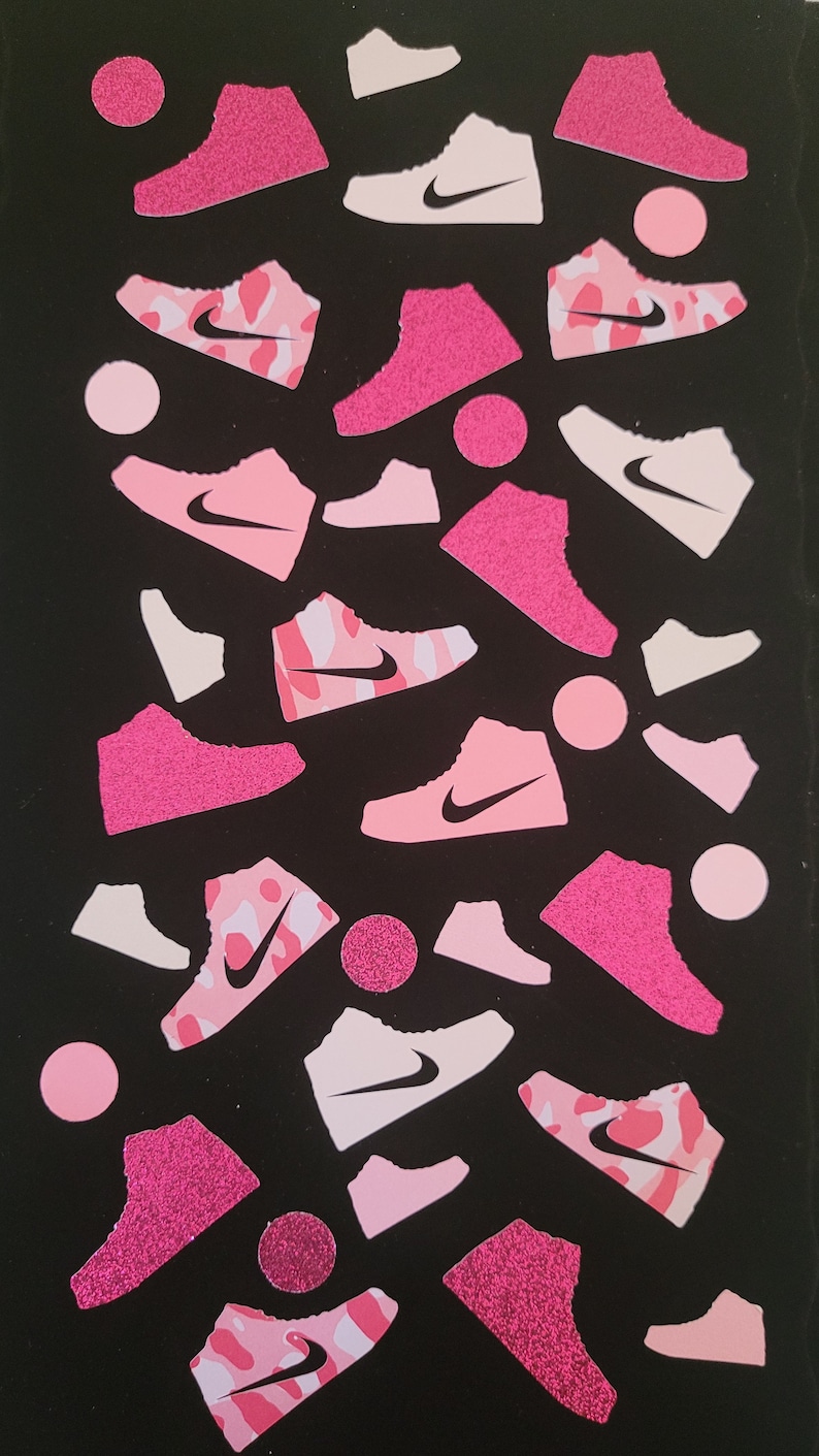 Może przedstawiać: R&oacute;żowe i białe buty sportowe z czarnym logo Swoosh na czarnym tle. Buty są w r&oacute;żnych kształtach i rozmiarach, niekt&oacute;re z błyszczącym wykończeniem.