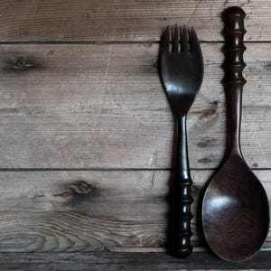 Peut inclure: Une fourchette en bois brun foncé et une cuillère en bois brun foncé assortie. Les deux ustensiles présentent un long manche fin avec une série de crêtes décoratives arrondies le long de la poignée, affichant une finition lisse et polie.