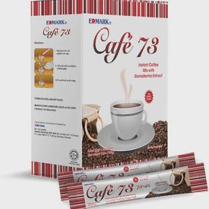 Può includere: Una scatola di caffè istantaneo Cafe 73 con estratto di Ganoderma, con una tazza di caffè su un piattino, chicchi di caffè e due bustine di caffè individuali. La scatola ha dettagli a righe rosse e bianche e istruzioni.