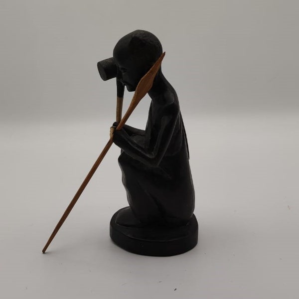 Figurine africaine vintage représentant un homme assis tenant une lance