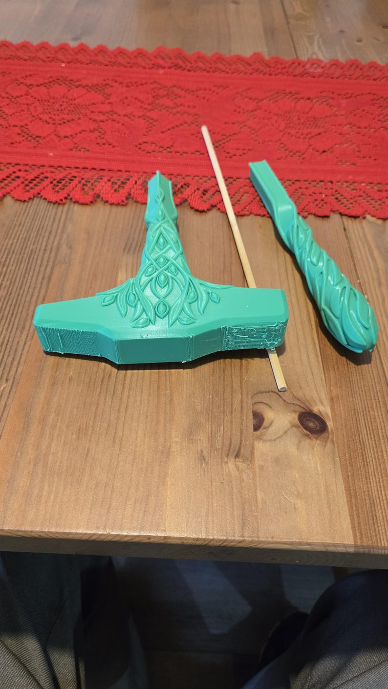May include: A green plastic hammer with a detailed design, a wooden stick, and a green plastic handle with a similar design.