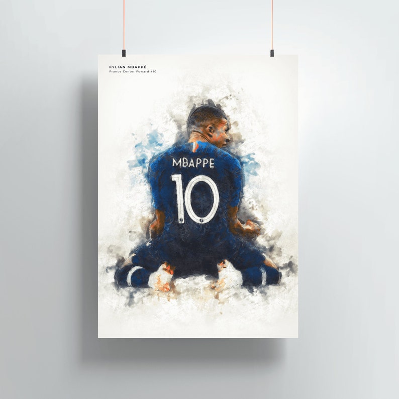May include: A watercolor painting of a soccer player wearing a blue jersey with the number 10 and the name "MBAPPE" on the back. The player is kneeling on the field with their back to the viewer.