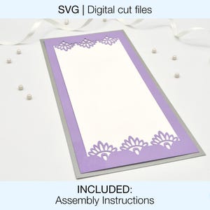 May include: A purple and silver card with a decorative cut-out design. The card is blank inside and has a white border. The text "INCLUDED: Assembly Instructions" is at the bottom of the image.