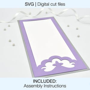 May include: A purple and silver card with a cut-out design of clouds. The text "INCLUDED: Assembly Instructions" is at the bottom of the card.