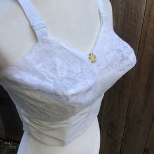 May include: White lace bra with adjustable straps and a small yellow flower embellishment.