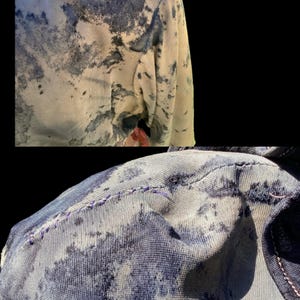 May include: Close-up of a garment with a unique pattern. The fabric features a blend of light beige and dark blue, creating a mottled effect. The stitching is visible, and the letters "BSC" are embroidered on the shoulder.