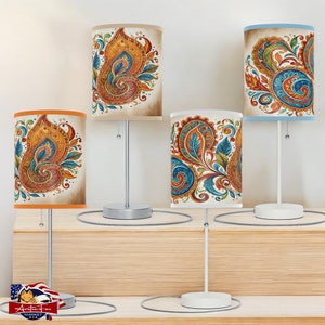 May include: Four table lamps with white bases and different patterned lampshades. The lampshades feature a paisley design with shades of orange, blue, and green.
