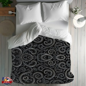 May include: A black and silver patterned duvet cover with a swirling, ornate design. The duvet cover is on a bed with white sheets and pillows.