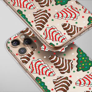 May include: Clear phone cases with a festive Christmas tree and gingerbread cookie pattern. The design features brown and white gingerbread cookies with red stripes, green Christmas trees, and red and green stars on a beige background.