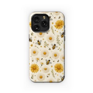 May include: A white iPhone case with a pattern of yellow daisies and black and yellow bees. The case has a black camera bump with three lenses.