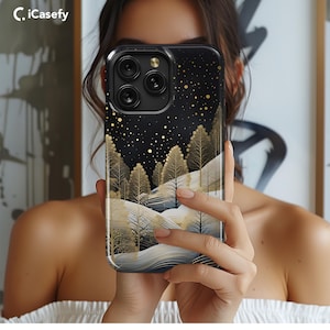 May include: A black phone case with a gold glitter design and a winter scene with trees and snow. The case has a black background with gold glitter and a white winter scene with trees and snow. The case has a cutout for the phone's camera.